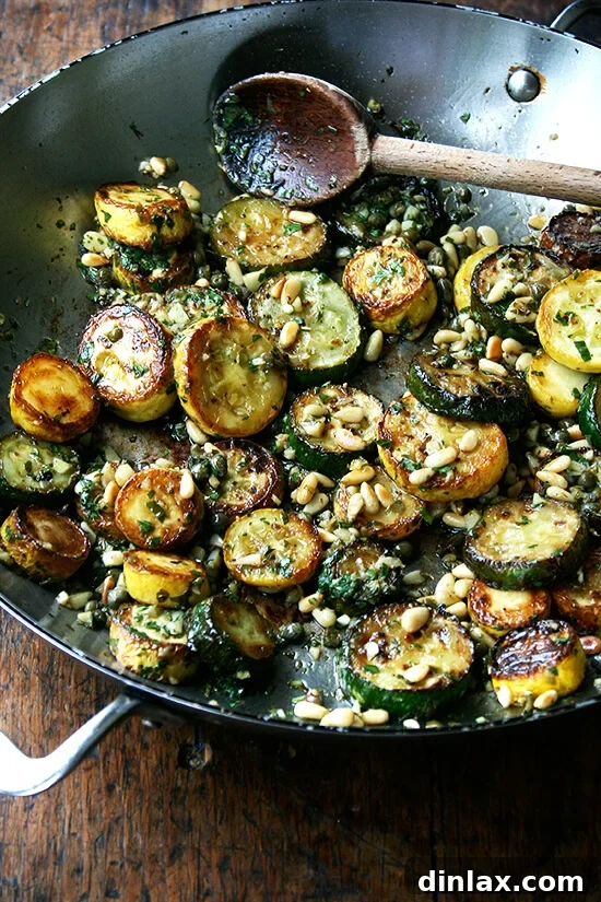 Bright Zucchini Sauté with Mint, Basil and Pine Nuts 6 Finished sautéed zucchini dish garnished with fresh mint, basil, and crunchy pine nuts on a white plate.