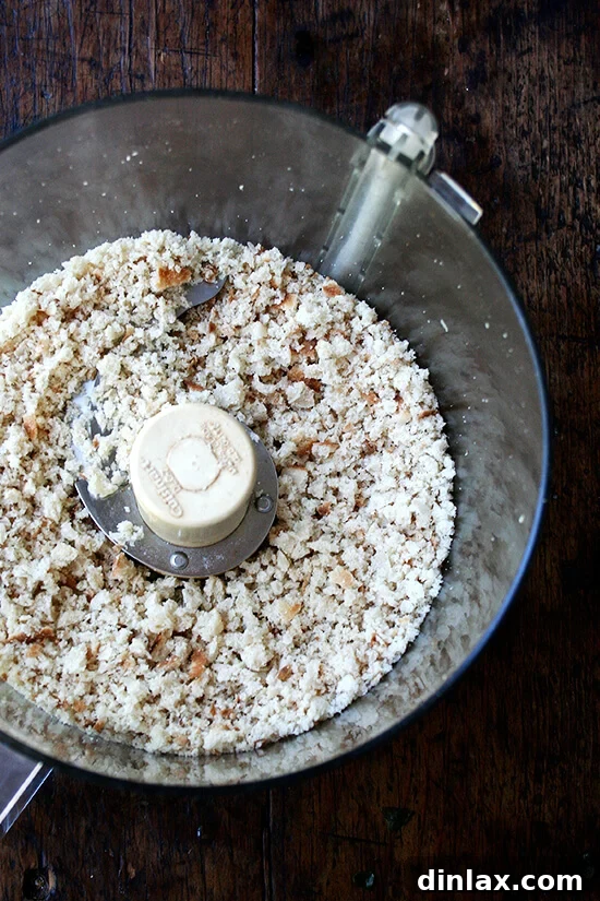 Tangy Swiss Chard Salad with Parmesan and Crunchy Breadcrumbs 5 Stale bread being pulsed into fine crumbs within a food processor bowl.