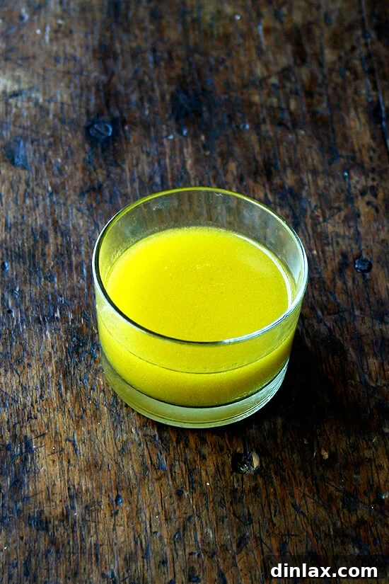 Tangy Swiss Chard Salad with Parmesan and Crunchy Breadcrumbs 6 A glass jar filled with a freshly made lemon dressing, ready to be shaken and poured.