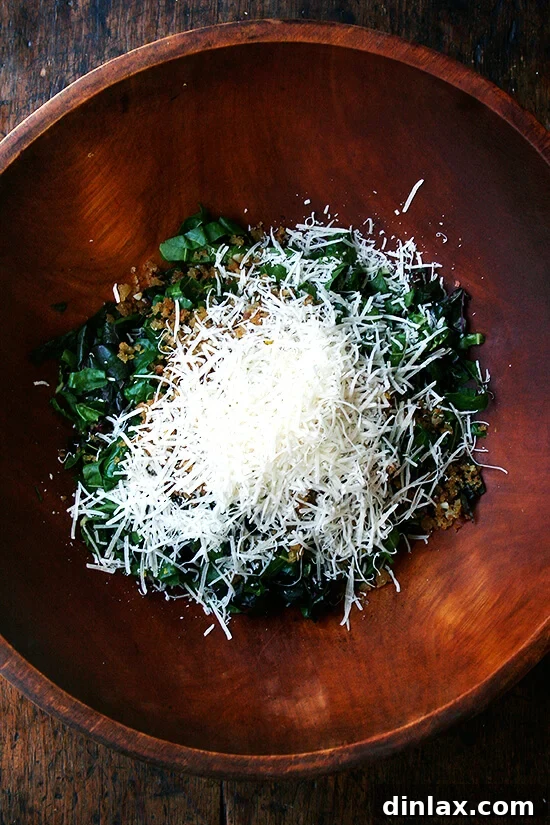 Tangy Swiss Chard Salad with Parmesan and Crunchy Breadcrumbs 8 A vibrant Swiss chard salad mixture topped with freshly shaved Parmesan cheese, awaiting the dressing.