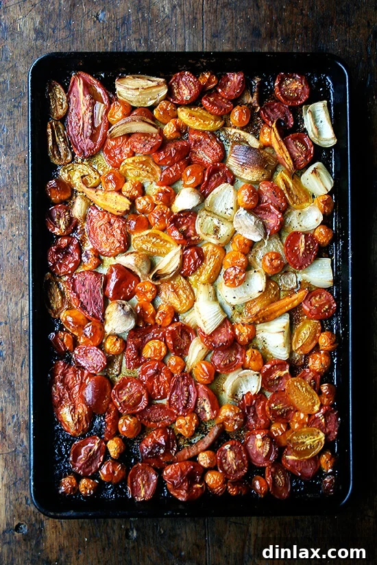 A sheet pan filled with beautifully roasted vegetables—tomatoes, onions, carrots, and garlic—golden and tender after slow cooking.
