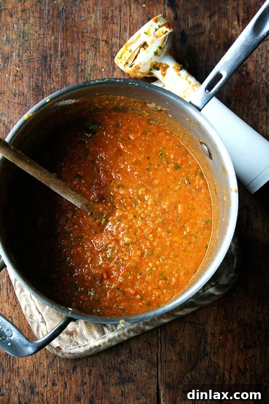 A rustic pot filled with rich, puréed roasted tomato and bread soup, showcasing its delightful chunky yet smooth consistency.