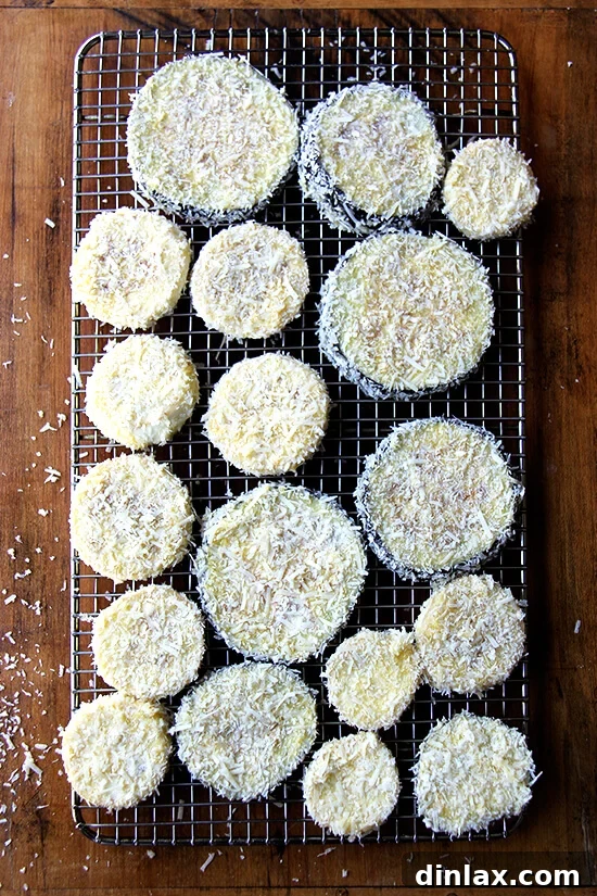 breaded eggplant slices arranged on a wire cooling rack, ready for baking