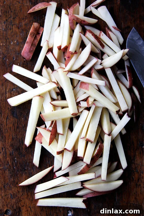 Golden Crispy Oven Fries 4 A board of uniformly cut potato sticks.