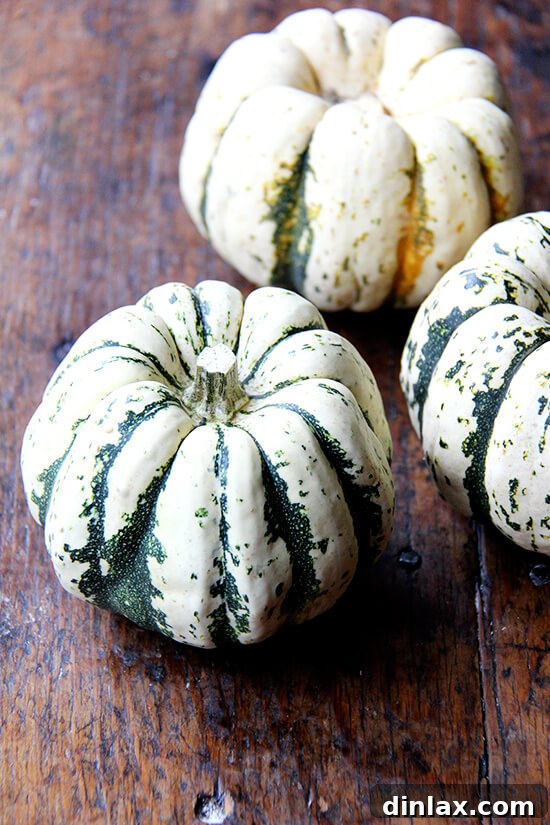 Caramelized Maple Acorn Squash 6 Three perfectly ripe acorn squash waiting to be prepared on a rustic wooden table.