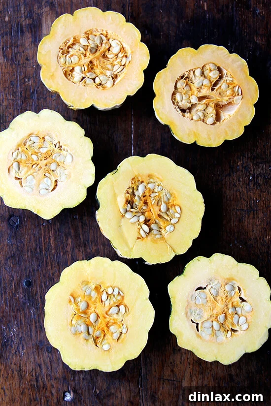 Caramelized Maple Acorn Squash 7 Three acorn squash cut in half, revealing their bright orange flesh and ready for seeding.