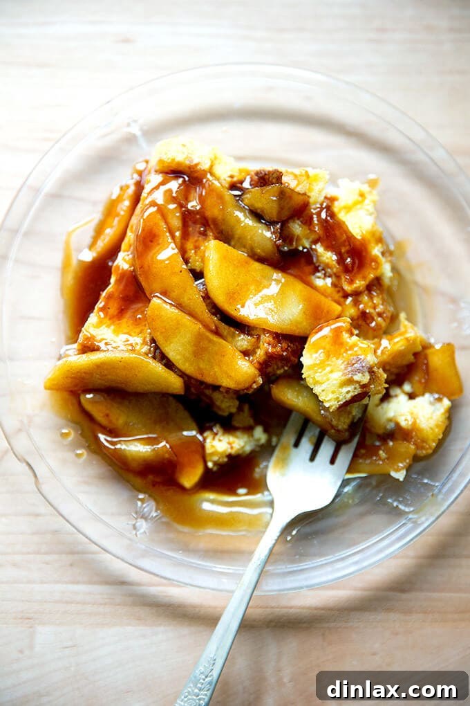 A plate of brioche bread pudding topped with apples sautéed in butter and caramel sauce.