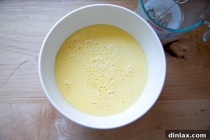 A bowl filled with the custard to make brioche bread pudding.