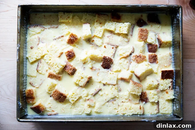 A 9x13-inch pan filled with toasted brioche cubes soaked in a custard after 30 minutes.