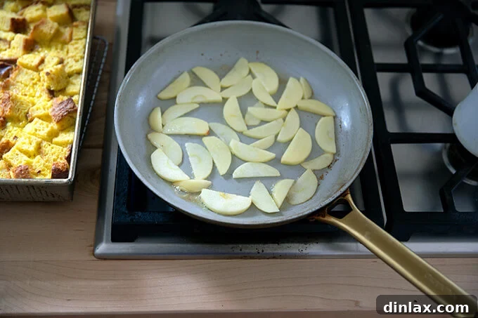 A skillet filled with sliced apples and butter.