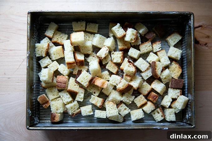 Cubes of toasted brioche in a 9x13-inch baking pan.