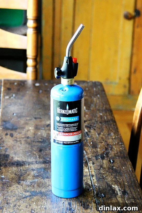 A BernzOmatic blowtorch, essential for achieving the perfect bruléed meringue fluff, sitting ready for use.