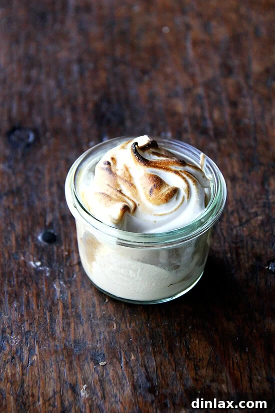 A scoop of dulce de leche ice cream generously topped with homemade meringue fluff, awaiting the final torching.