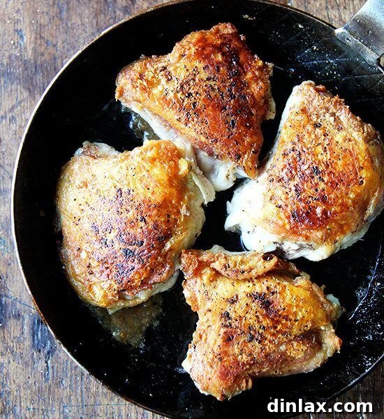 Crispy chicken thighs with preserved lemon in a skillet.