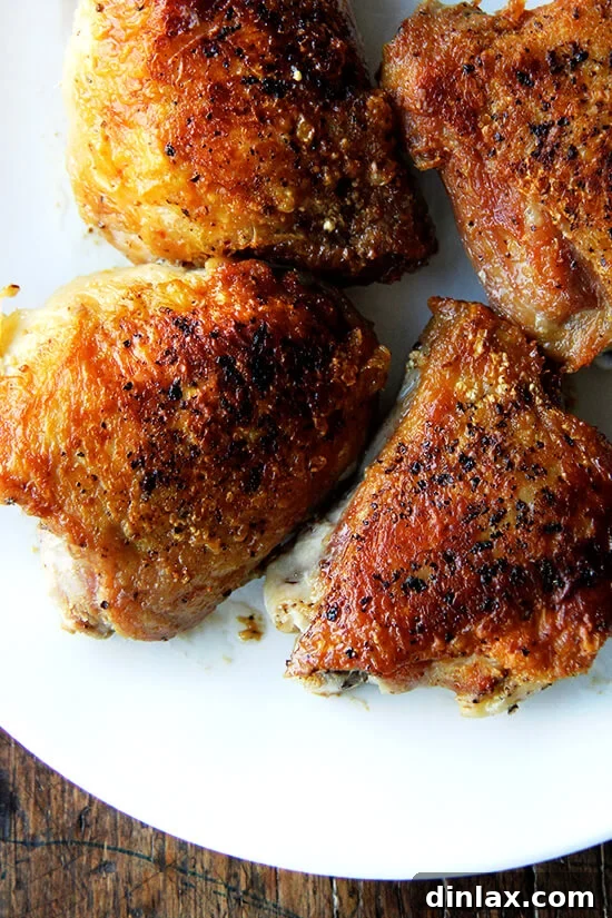 An overhead shot of crispy chicken thighs artfully arranged on a plate. 
