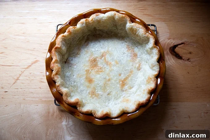 Golden Roasted Butternut Bliss Pie 13 A golden-brown, parbaked pie crust resting on a cooling rack, ready to be filled.