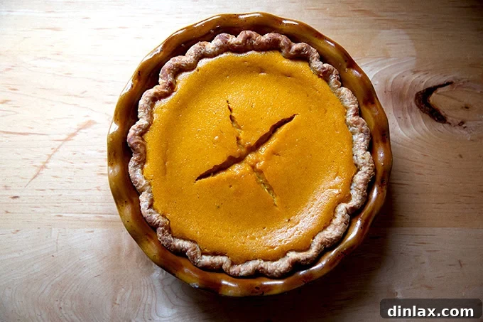 Golden Roasted Butternut Bliss Pie 16 A freshly baked butternut squash pie on a cooling rack, showing a minor crack on its surface, still delicious.