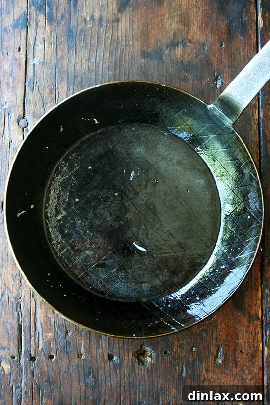 The Turk Forged Iron Fry Pan, easily cleaned with a quick wipe, demonstrating its low-maintenance care.