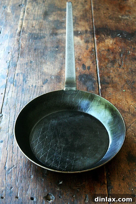 A gentle scrub of the Turk Forged Iron Fry Pan, showcasing its durable and easy-to-maintain surface.