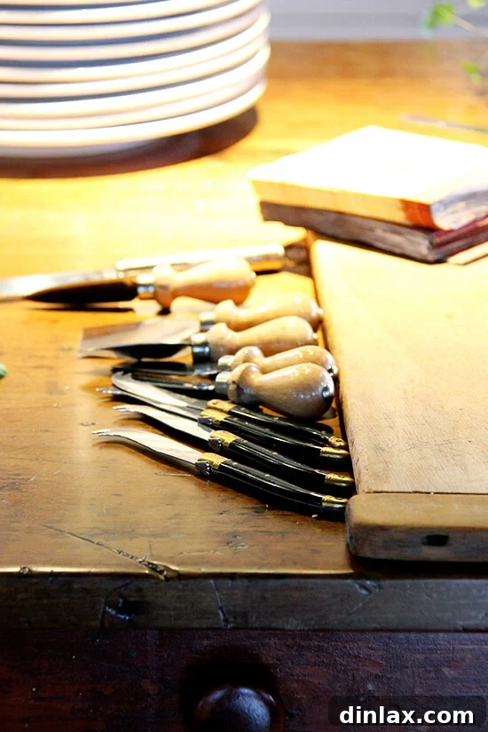 A selection of cheese knives neatly arranged on a table, hinting at a cheese course.