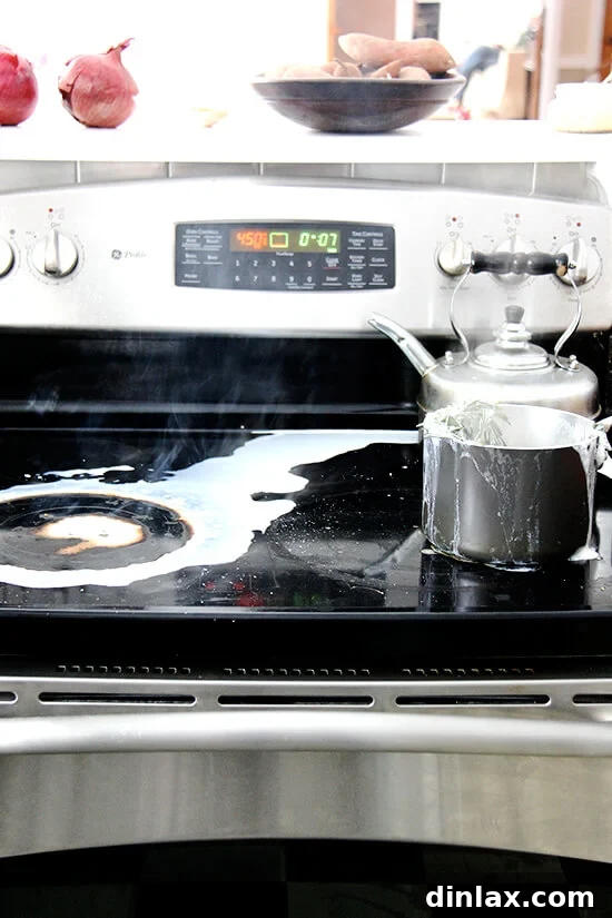 A stovetop mess with a saucepan that has visibly overflowed with boiling milk.