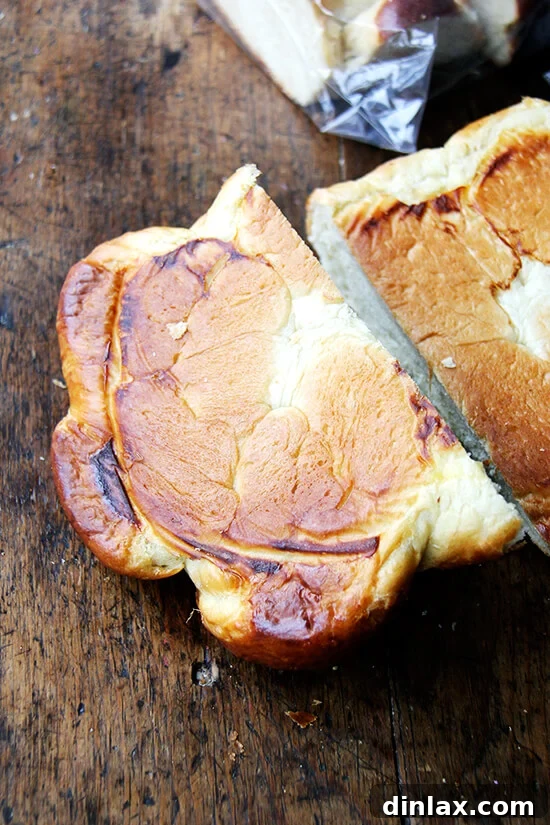 The perfectly golden underside of a baked Challah bread loaf, showcasing the success of the double sheet pan method.
