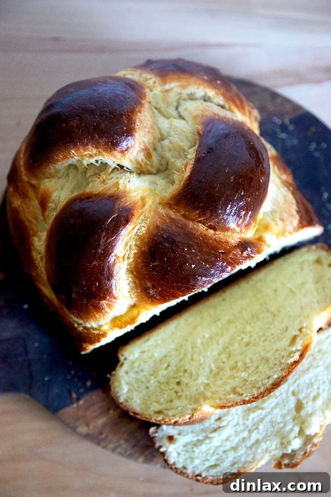 Slices of golden Challah bread neatly arranged on a wooden board, showcasing its airy crumb.