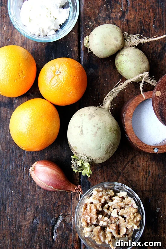 Vibrant Watermelon Radish, Orange, and Goat Cheese Salad 2 Watermelon radishes, goat cheese, salt, walnuts, and shallots laid out on a wooden board for salad preparation.