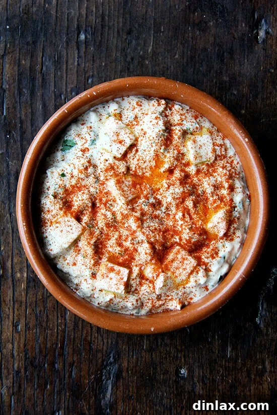 Martha Stewart's Legendary Hot Crab Dip 6 Hot crab dip mixture in a baking dish, perfectly topped with a golden breadcrumb and paprika crust, ready for the oven to transform it into a bubbling delight.