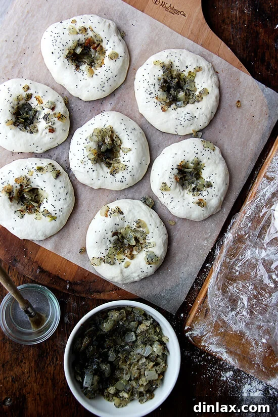 Your Guide to Perfect Homemade Bialys 12 Bialys generously filled with savory onion-poppy seed mixture, ready for the oven.