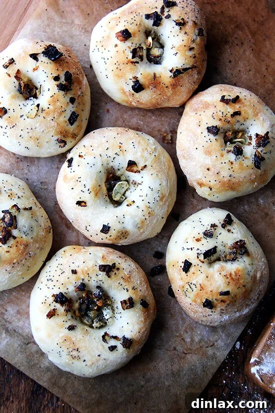 Every batch of bialys disappears quickly — the onion-poppy seed-breadcrumb filling/topping, whose flavor permeates the whole bialy, is irresistible. Later in the day we halve them and spread them with softened butter or cream cheese. For dinner we toast them under the broiler, one half covered with a slice of cheddar, and then, upon pulling them from the oven, we slide a fried egg onto the uncheesed half and hit it with a healthy squirt of Sriracha. // alexandracooks.com A fresh batch of just-baked golden bialys, perfectly puffed and ready to enjoy.