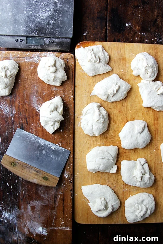 Your Guide to Perfect Homemade Bialys 4 Portioned bialy dough pieces arranged on a board, ready for shaping.