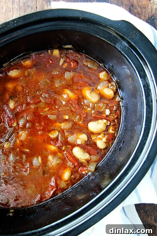 A close-up view of slow cooker white beans, after six hours of gentle cooking, showing their creamy texture and rich, flavorful broth.