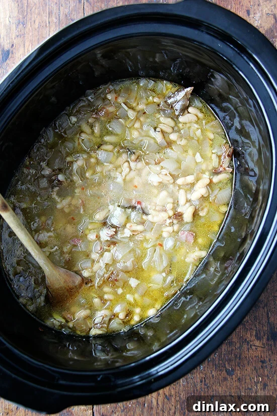 Slow cooker interior showing perfectly cooked flageolet beans after six hours.