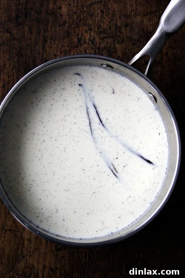 Velvet Vanilla Bean Custard 3 Vanilla bean pods, split lengthwise to reveal tiny black seeds, infusing rich cream for a flavorful dessert.