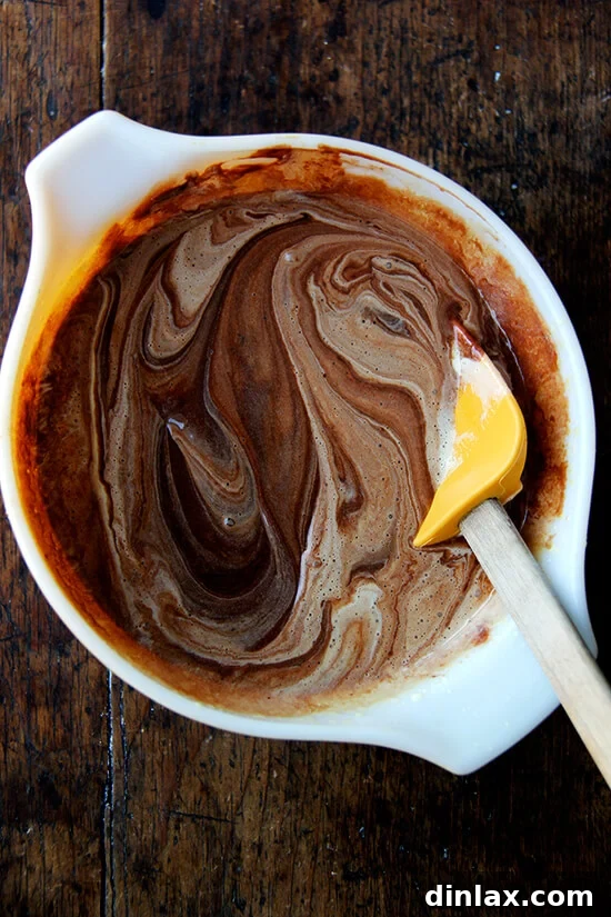 Julia Child's Signature Chocolate Mousse 5 A bowl showing melted chocolate and the thick, pale egg yolk mixture stirred together, forming the rich base of the chocolate mousse.