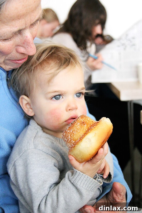 Fresh Threads of Vergennes 11 A child, Wren, happily holding a morning bun, indicating its irresistible appeal