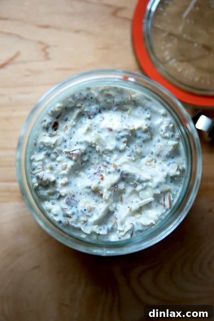 A transparent jar showcasing layers of overnight Bircher muesli, topped with fresh fruit, ready to be enjoyed as a convenient and healthy breakfast.