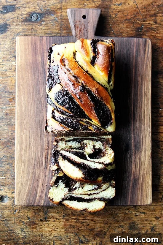 A stunning image of orange-chocolate babka, showcasing its beautiful layers and inviting texture. This babka hybrid is so delicious, it's hard to resist! A beautifully sliced orange-chocolate babka loaf on a wooden board, showcasing its intricate swirls and golden crust.