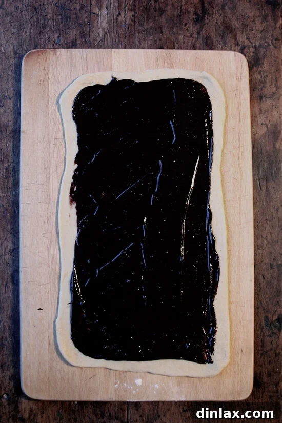 Mastering Chocolate Swirl Babka 6 A sheet of rolled-out babka dough generously spread with a layer of rich chocolate filling.