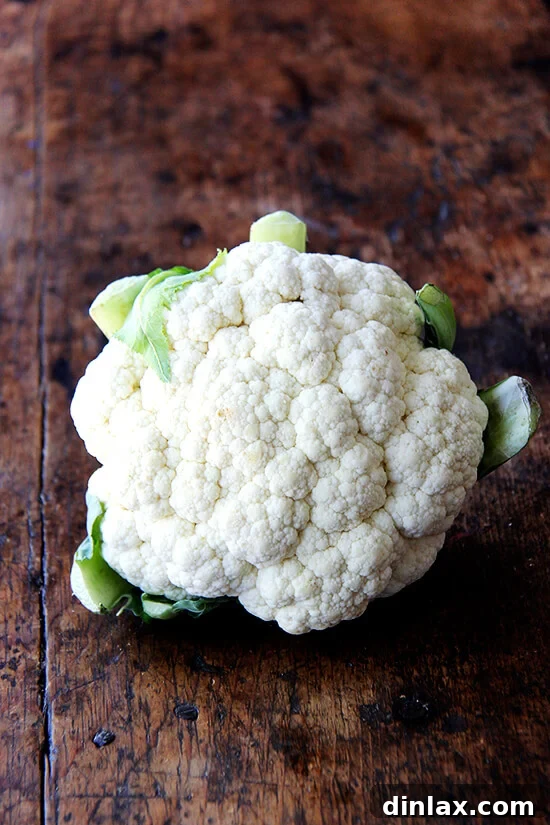 Fresh, uncooked head of cauliflower, ready for preparation.