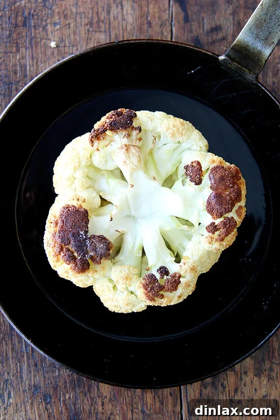 Golden-brown whole roasted cauliflower, just out of the oven, perfectly tender.