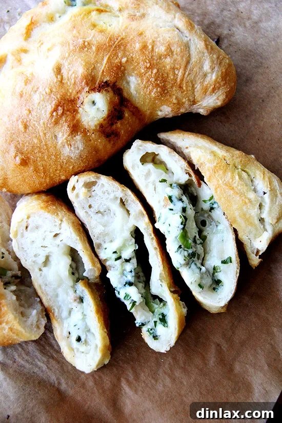 A calzone sliced into rounds reveals its heavenly, oozing mix of goat cheese, mozzarella, herbs, and prosciutto—a truly light and spring-like gourmet experience, perfect for any gathering.