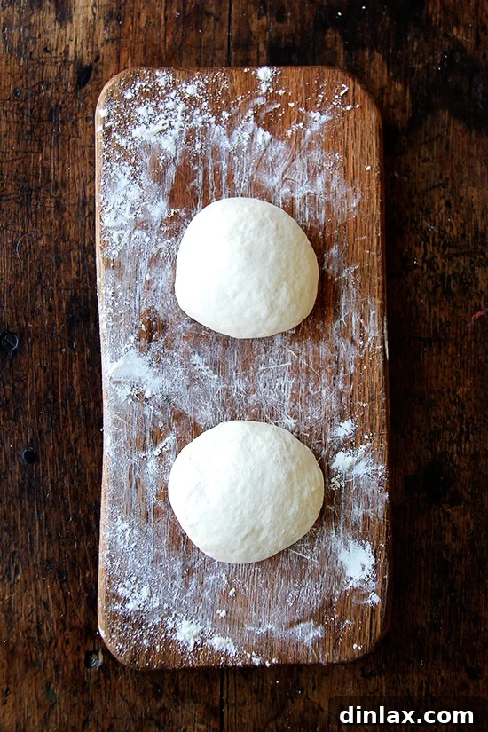 Smooth, evenly sized pizza dough balls, rested and ready for rolling into calzone rounds.