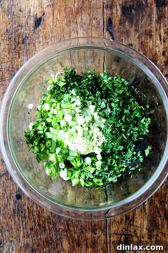 Briny Egg Salad Crostini 4 A bowl of creamy mayonnaise mixed with finely chopped scallions and parsley, forming the vibrant dressing base for the egg salad.