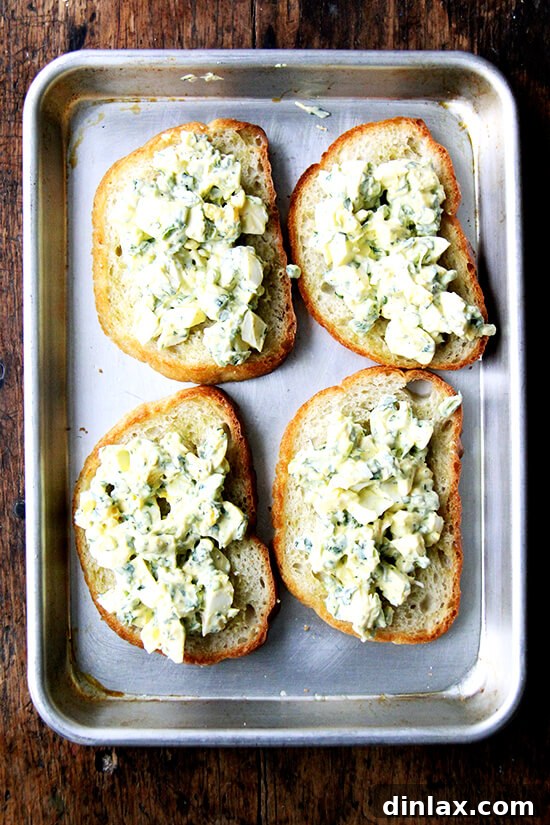 Briny Egg Salad Crostini 10 A generous dollop of pickled egg salad placed on a golden-brown, garlic-rubbed toast, ready for garnishing.