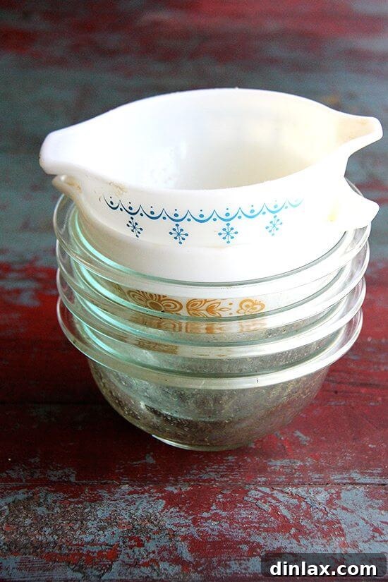 The Book's Revelation 10 A stack of durable Pyrex glass bowls, ideal for mixing and proofing peasant bread dough, alongside a vintage Pyrex bowl.