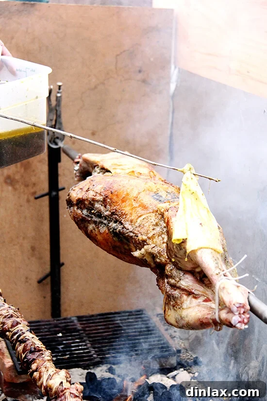 A close-up of the succulent lamb being basted on the spit, its skin glistening and aroma filling the air.