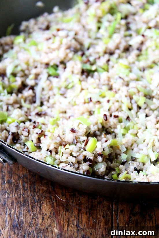 The vibrant mixture of rice and leeks being stir-fried in the skillet, showcasing a harmonious blend of ingredients.