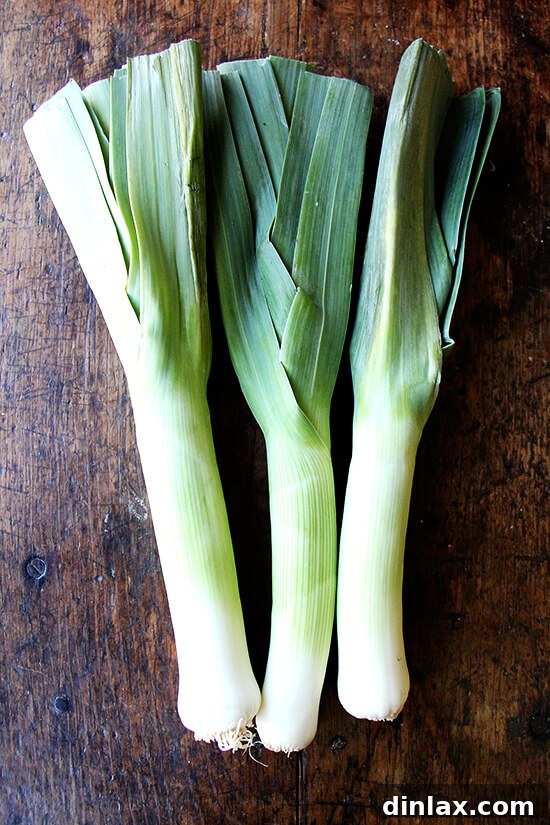 Fresh leeks, meticulously sliced and prepared for cooking, highlighting their vibrant green and white parts.